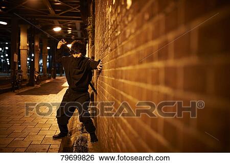 Stock Photograph - Japanese ninja at night downtown Tokyo. Fotosearch