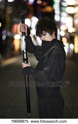 Stock Photography - Japanese ninja at night downtown Tokyo. Fotosearch