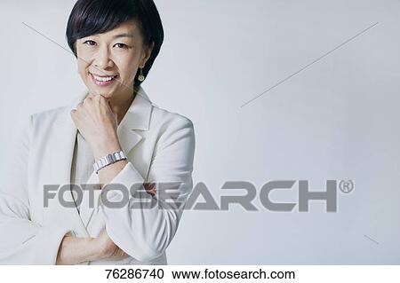 Japanese senior businesswoman against white wall View Large Photo Image Stock Image - Japanese senior businesswoman against white wall. Fotosearch