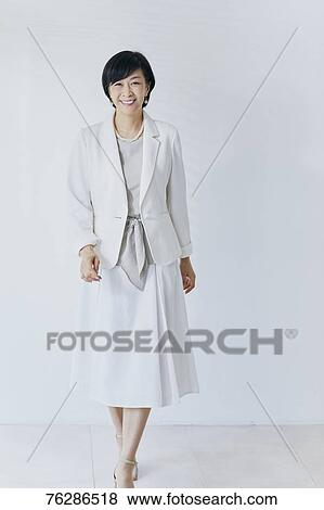 Stock Photo - Japanese senior businesswoman against white wall. Fotosearch