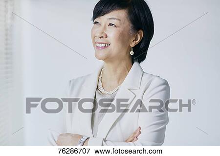 Japanese senior businesswoman against white wall View Large Photo Image Stock Photo - Japanese senior businesswoman against white wall. Fotosearch