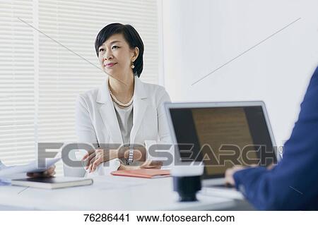 Stock Image - Japanese senior businesswoman having meeting in the office. Fotosearch