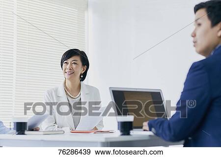 Stock Photo - Japanese senior businesswoman having meeting in the office. Fotosearch