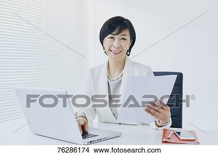 Picture - Japanese senior businesswoman in the office. Fotosearch