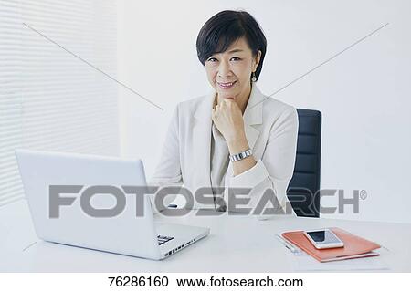 Stock Image - Japanese senior businesswoman in the office. Fotosearch