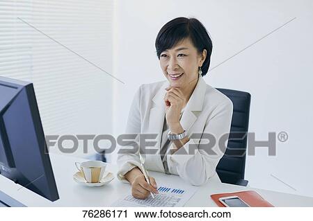 Stock Image - Japanese senior businesswoman in the office. Fotosearch