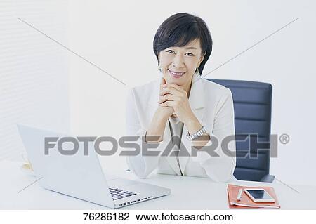 Stock Image - Japanese senior businesswoman in the office. Fotosearch