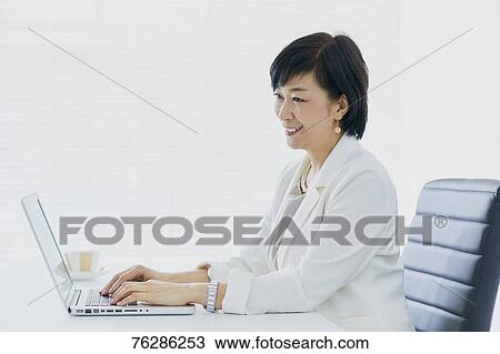 Stock Image - Japanese senior businesswoman in the office. Fotosearch