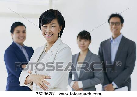 Stock Image - Japanese senior businesswoman with her team. Fotosearch
