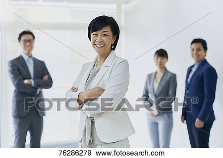 Stock Photo - Japanese senior businesswoman with her team. Fotosearch