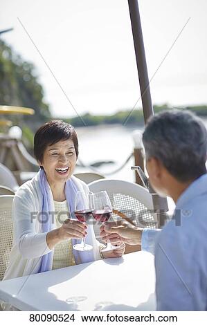 Picture - Japanese senior couple having a drink by the sea. Fotosearch