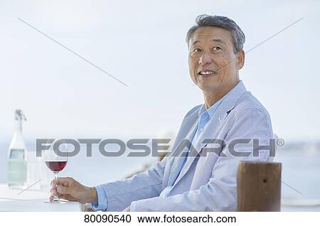 Stock Image - Japanese senior couple having a drink by the sea. Fotosearch