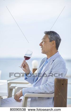 Stock Photo - Japanese senior couple having a drink by the sea. Fotosearch