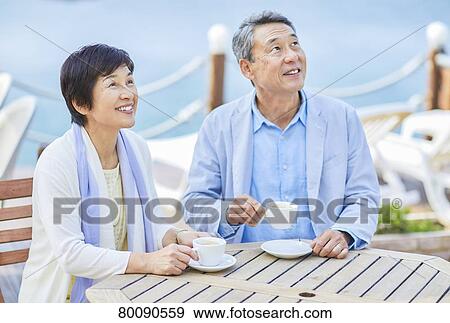 Japanese senior couple having a drink by the sea View Large Photo Image Stock Photo - Japanese senior couple having a drink by the sea. Fotosearch
