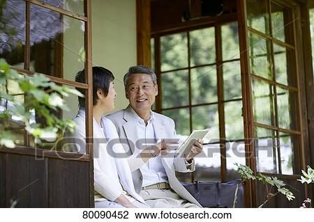 Stock Image - Japanese senior couple having fun at traditional inn. Fotosearch