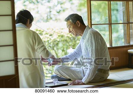 Stock Image - Japanese senior couple having fun at traditional inn. Fotosearch