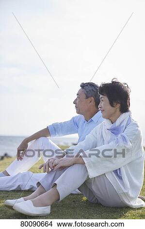 Picture - Japanese senior couple having fun by the sea. Fotosearch