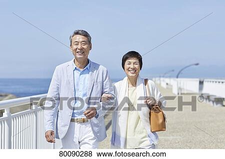 Japanese senior couple having fun by the sea View Large Photo Image Stock Photo - Japanese senior couple having fun by the sea. Fotosearch