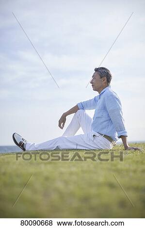 Stock Photo - Japanese senior couple having fun by the sea. Fotosearch