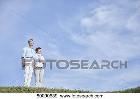 Stock Photo - Japanese senior couple having fun by the sea. Fotosearch
