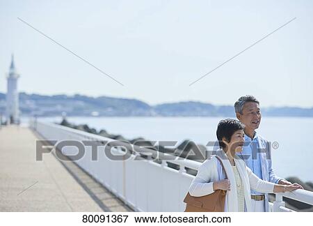 Japanese senior couple having fun by the sea View Large Photo Image Stock Photo - Japanese senior couple having fun by the sea. Fotosearch