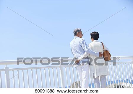 Stock Photo - Japanese senior couple having fun by the sea. Fotosearch