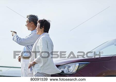 Stock Photo - Japanese senior couple having fun by the sea. Fotosearch