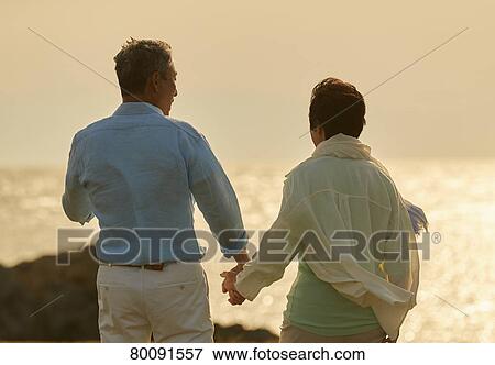 Japanese senior couple having fun by the sea View Large Photo Image Stock Photo - Japanese senior couple having fun by the sea. Fotosearch