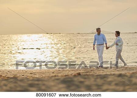 Japanese senior couple having fun by the sea View Large Photo Image Stock Photo - Japanese senior couple having fun by the sea. Fotosearch