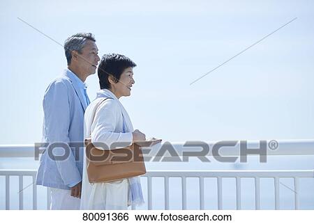 Japanese senior couple having fun by the sea View Large Photo Image Stock Photograph - Japanese senior couple having fun by the sea. Fotosearch