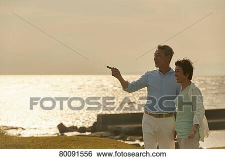 Japanese senior couple having fun by the sea View Large Photo Image Stock Photograph - Japanese senior couple having fun by the sea. Fotosearch