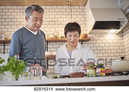 Picture - Japanese senior couple in the kitchen. Fotosearch