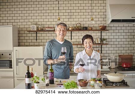 Picture - Japanese senior couple in the kitchen. Fotosearch