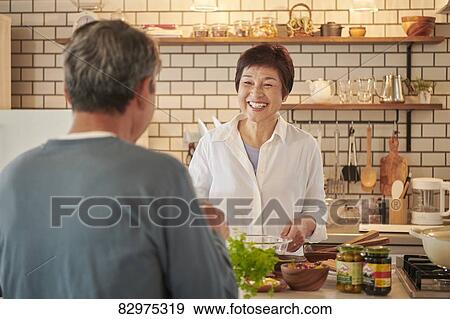 Stock Photo - Japanese senior couple in the kitchen. Fotosearch