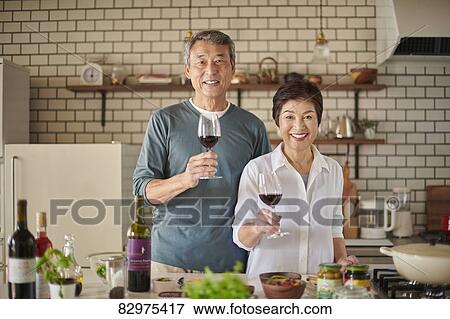 Stock Photo - Japanese senior couple in the kitchen. Fotosearch