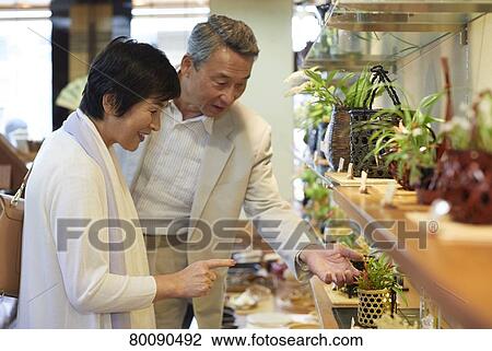 Stock Image - Japanese senior couple shopping. Fotosearch