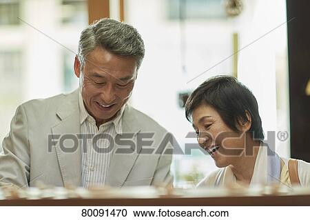 Stock Image - Japanese senior couple shopping. Fotosearch
