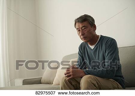 Stock Photo - Japanese senior man on the sofa. Fotosearch