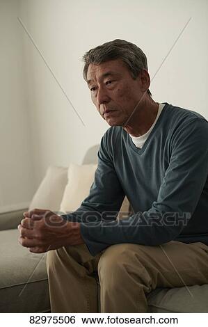 Stock Photograph - Japanese senior man on the sofa. Fotosearch