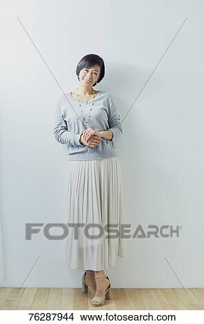 Picture - Japanese senior woman against white wall. Fotosearch