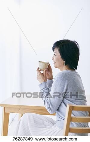 Stock Photo - Japanese senior woman having coffee. Fotosearch