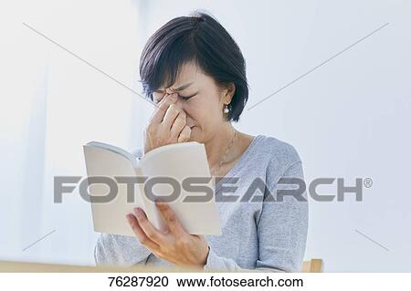 Stock Image - Japanese senior woman having headhache. Fotosearch