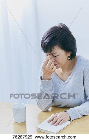 Stock Photo - Japanese senior woman having headhache. Fotosearch