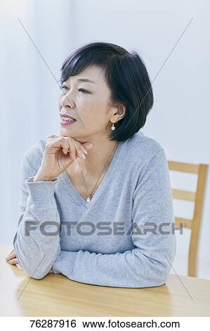 Stock Photograph - Japanese senior woman having headhache. Fotosearch