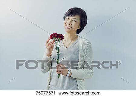 Japanese senior woman holding flowers View Large Photo Image Stock Image - Japanese senior woman holding flowers. Fotosearch