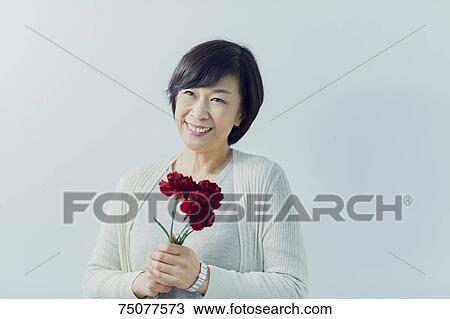 Japanese senior woman holding flowers View Large Photo Image Stock Image - Japanese senior woman holding flowers. Fotosearch