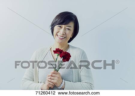 Japanese senior woman holding red roses View Large Photo Image Stock Image - Japanese senior woman holding red roses. Fotosearch
