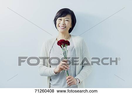 Japanese senior woman holding red roses View Large Photo Image Stock Photo - Japanese senior woman holding red roses. Fotosearch