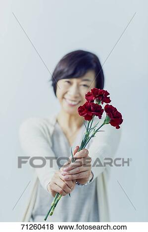 Japanese senior woman holding red roses View Large Photo Image Stock Photo - Japanese senior woman holding red roses. Fotosearch