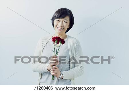 Japanese senior woman holding red roses View Large Photo Image Stock Photograph - Japanese senior woman holding red roses. Fotosearch